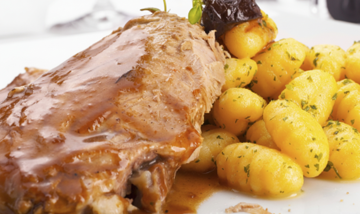 Pan Seared Fillet with Molasses Pan Sauce, Potato Gnocchi and Mustard Greens on a plate