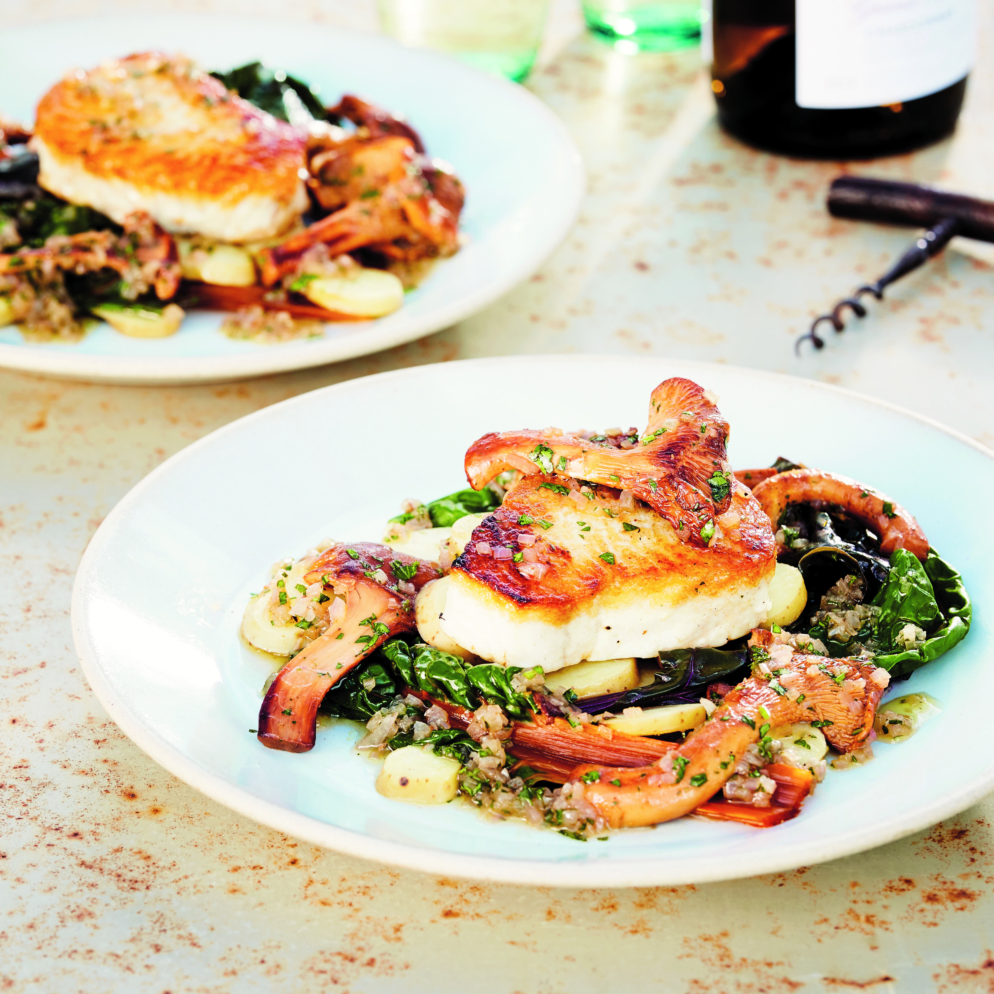 Pan-Seared White Fish with Chanterelle Vinaigrette, Fingerlings & Chard on a plate with a corkscrew
